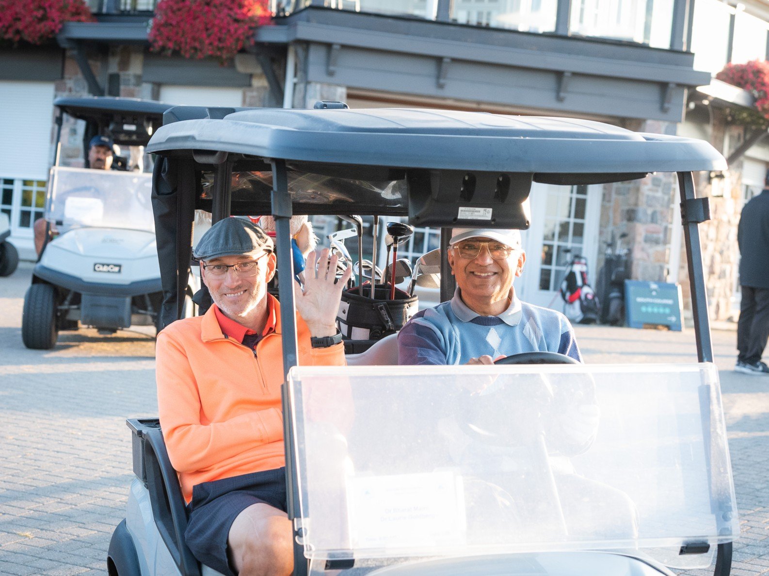 Dr. Laurie Goldberg and Dr. Bharat Maini in a golf cart